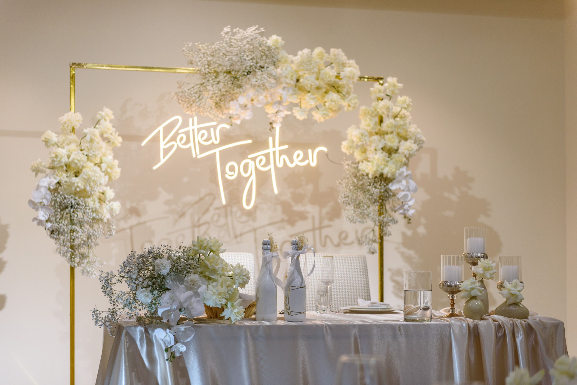 Festive table with arch decorated composition flowers and greenery, candles in hall restaurant. Table newlyweds covered with a tablecloth in banquet area on wedding party. Table setting, reception.